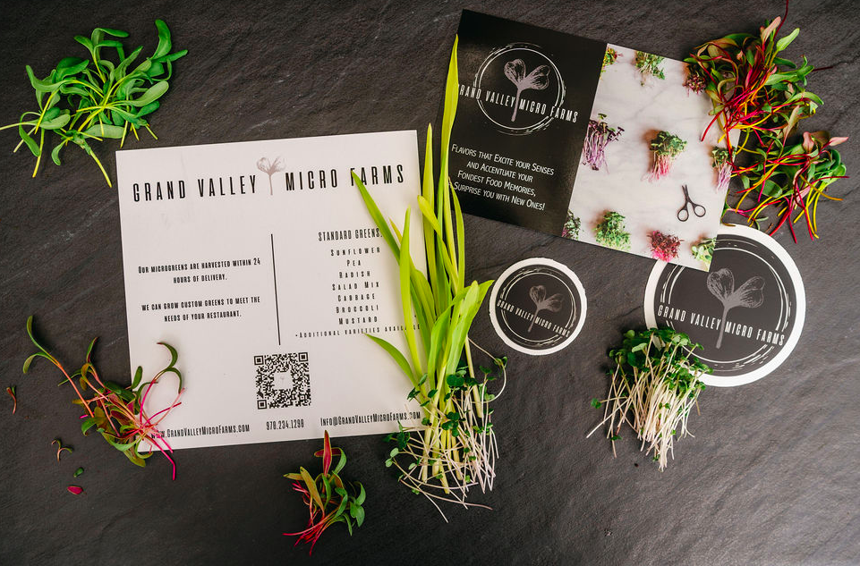 Promotional materials from Grand Valley Micro Farms featuring microgreens, a QR code, and information on available products and services, set against a dark slate background.